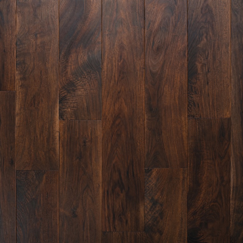 Straight-down view of dark walnut floorboards with rich grain variation